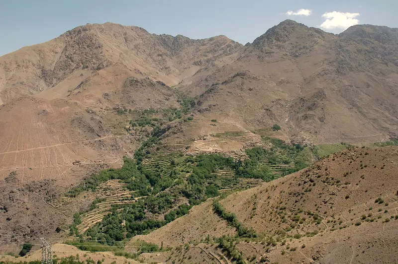 A Berber village of earthen houses across a valley in the Atlas